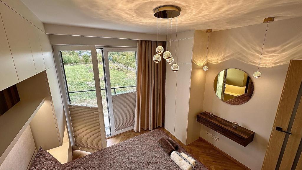 a bedroom with a bed and a mirror and a window at Apartament Słoneczny in Łańcut