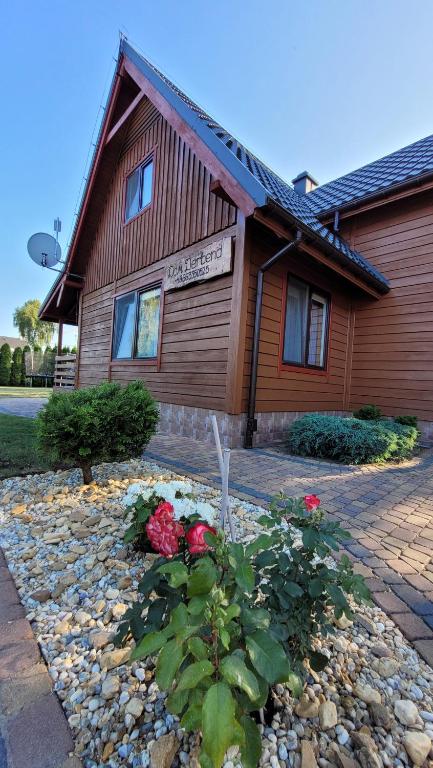 a building with a flower garden in front of it at Dom Derbend na wyłączność in Sztutowo