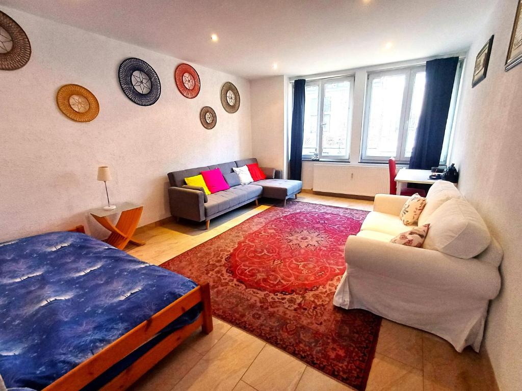 a bedroom with a bed and a living room with a couch at Plein centre de Visé in Visé