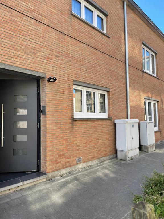 a brick building with a garage and a door at Gasthaus A&S - Oostende - Beach in Ostend