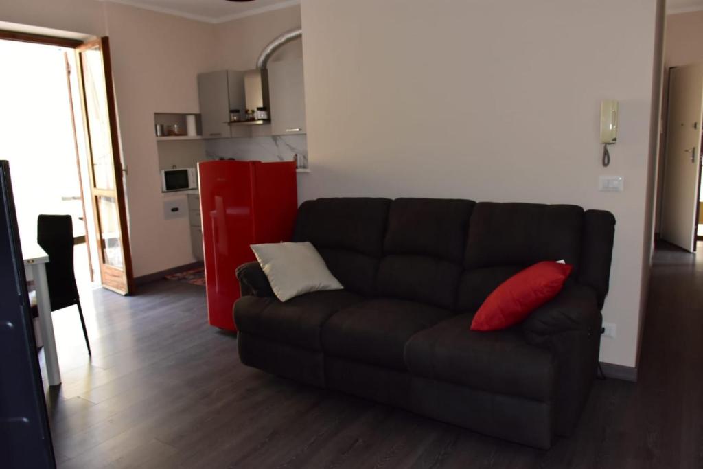 a living room with a black couch and a red refrigerator at Da Alessandro in Biella