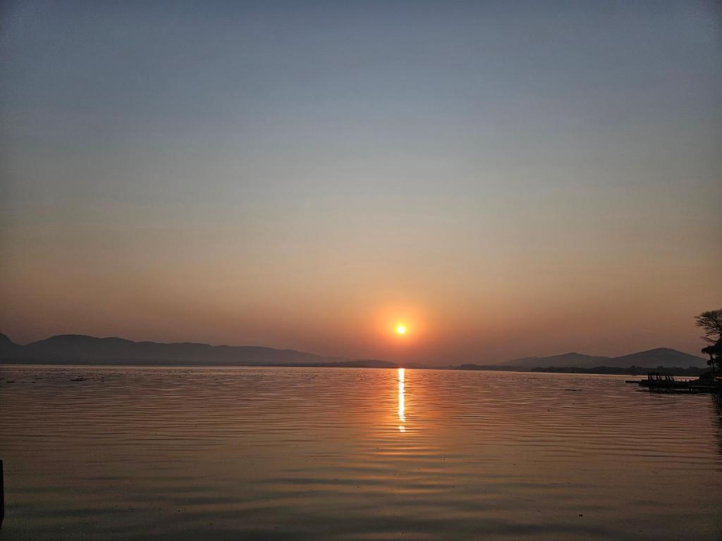 a sunset over a body of water at Pecanwood Home Away from Home in Hartbeespoort