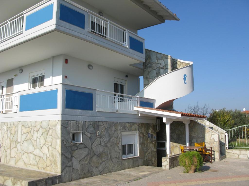 a large white building with blue windows and a balcony at Seaview Aparthotel in Nea Potidaea