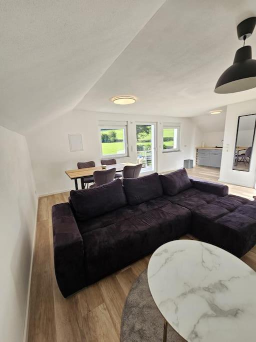 a living room with a couch and a table at Moderne Ferienwohnung Attendorn in Attendorn