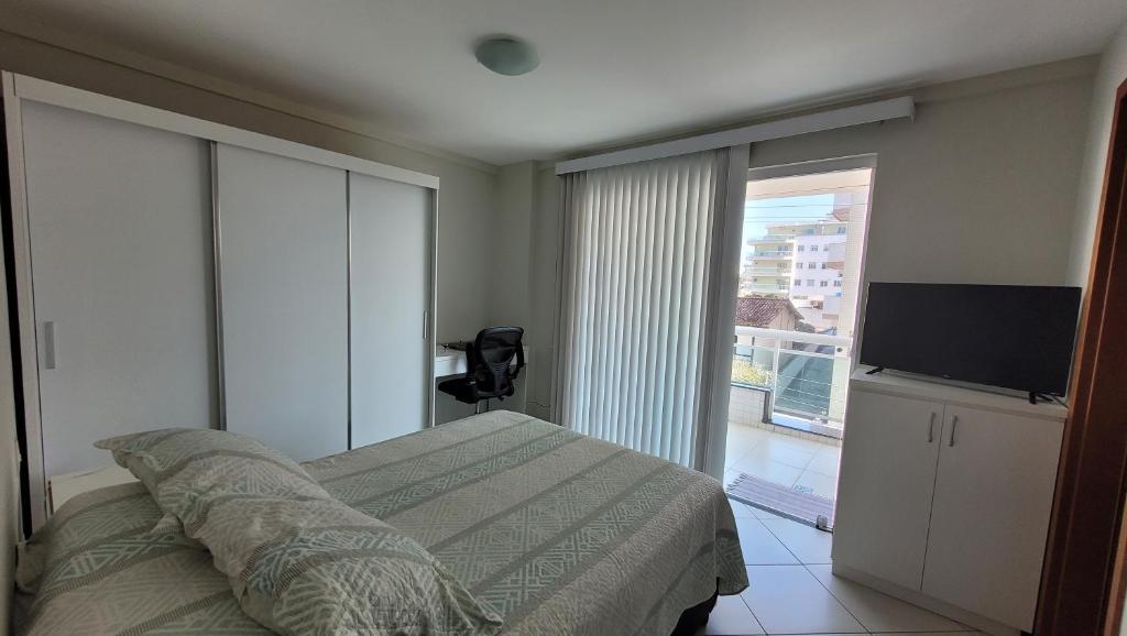 a bedroom with a bed and a flat screen tv at Apartamento em Cabo Frio - Braga - RJ in Cabo Frio