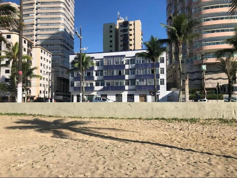 Cantinho à beira mar في برايا جراندي: ظل شخص على الشاطئ مع المباني