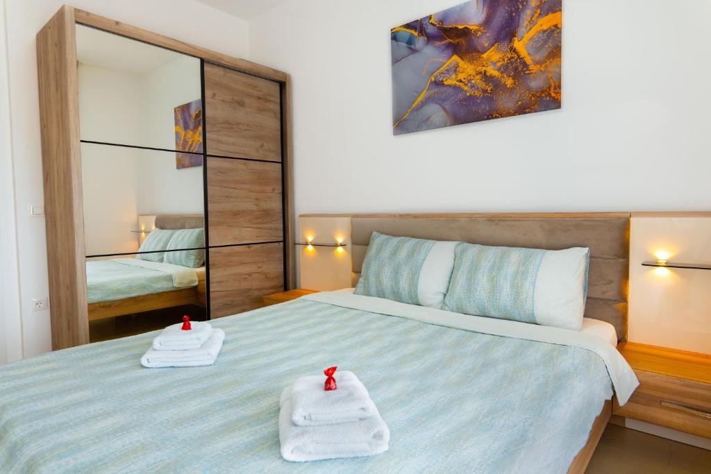 a bedroom with a bed with two towels on it at Harizma apartmani - Maja in Kragujevac