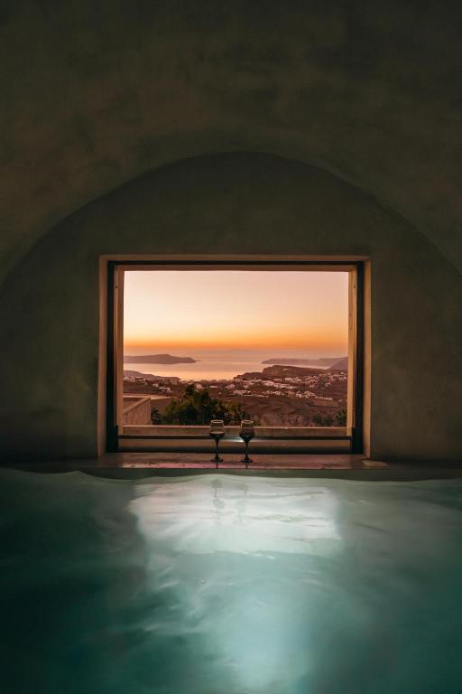 a room with a window looking out at the sunset at Aethra Vegan Caves in Pirgos