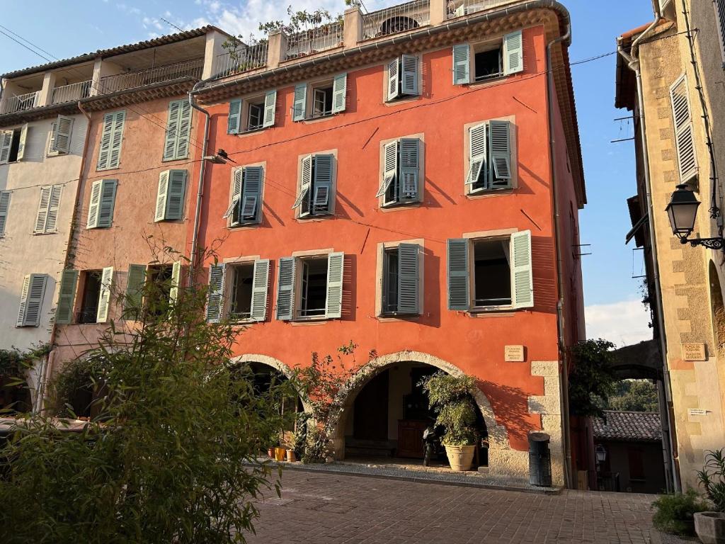 an orange building with an archway in a street at Biot - Place des Arcades in Biot