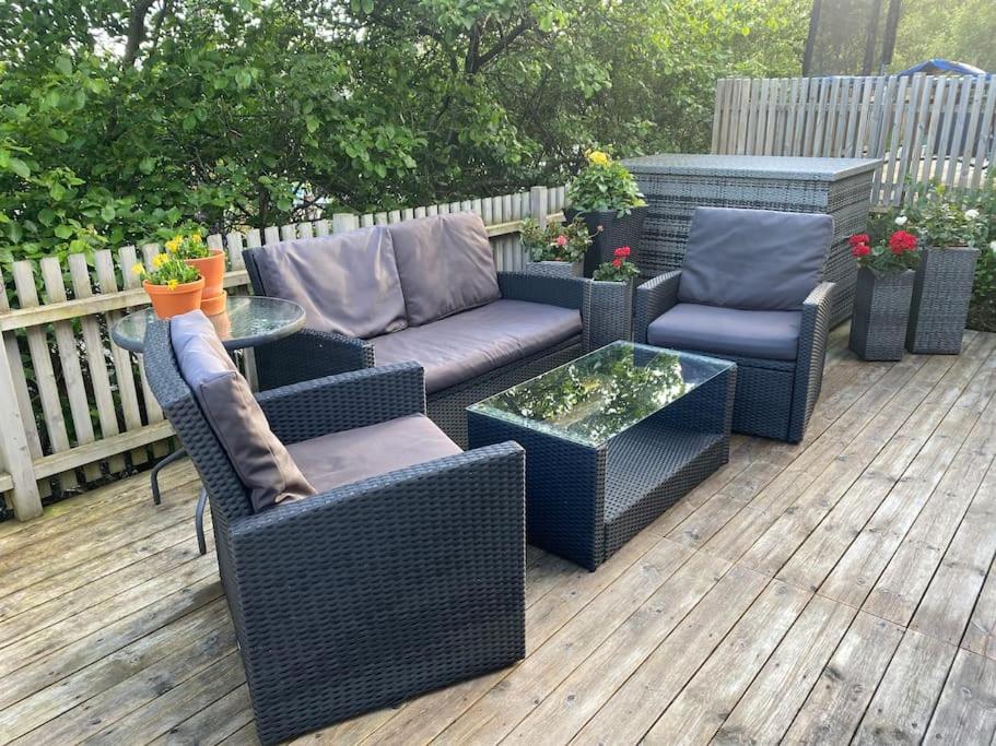 a deck with wicker furniture and a table and chairs at Trondheim sentrum, Lade - Nyhavna, gratis parkering in Trondheim