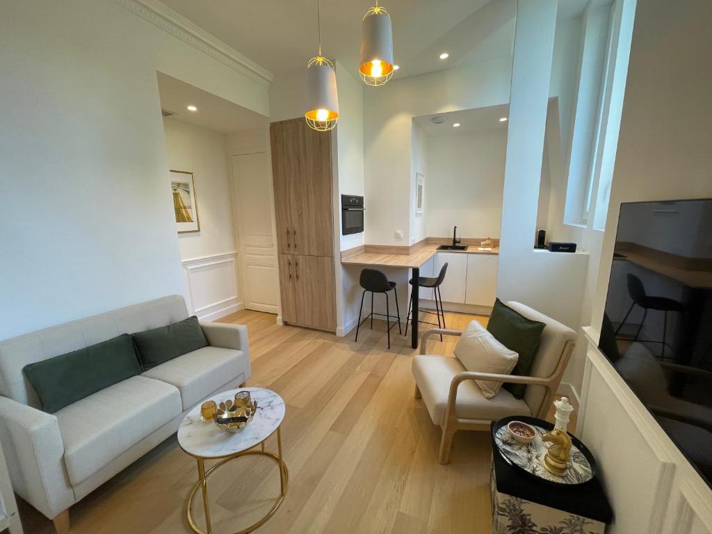 un salon avec un canapé et une table dans l'établissement Appartements de charme du Général Leclerc - Place d'Erlon - Hypercentre - Gare - Reims, à Reims