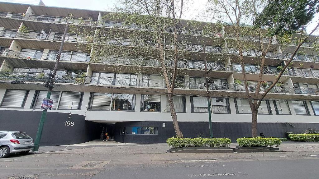 メキシコシティにあるCondominio Villalongin 196の建物の前に車が駐車されている