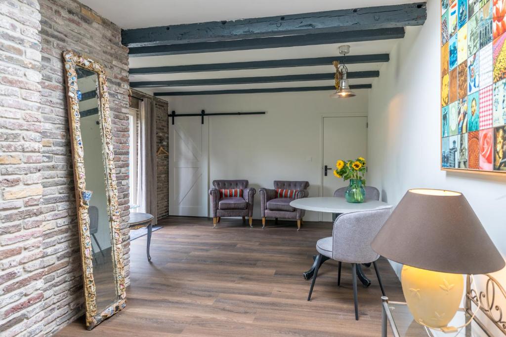 een kamer met een bakstenen muur en een spiegel bij B&B De Oude Skuur Texel in Oosterend