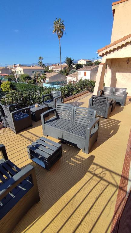 - une rangée de chaises longues sur une terrasse avec un palmier dans l'établissement Les studios des mandariniers, à Cagnes-sur-Mer