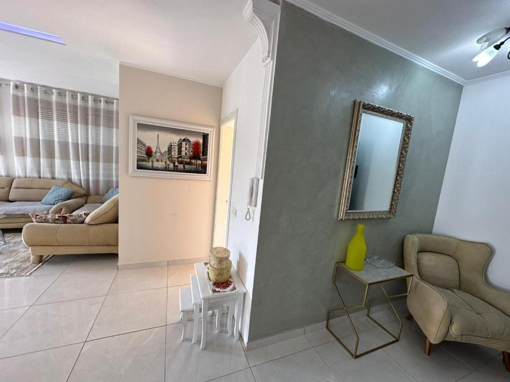 ティラナにあるAlma Guestのソファと鏡のあるリビングルーム