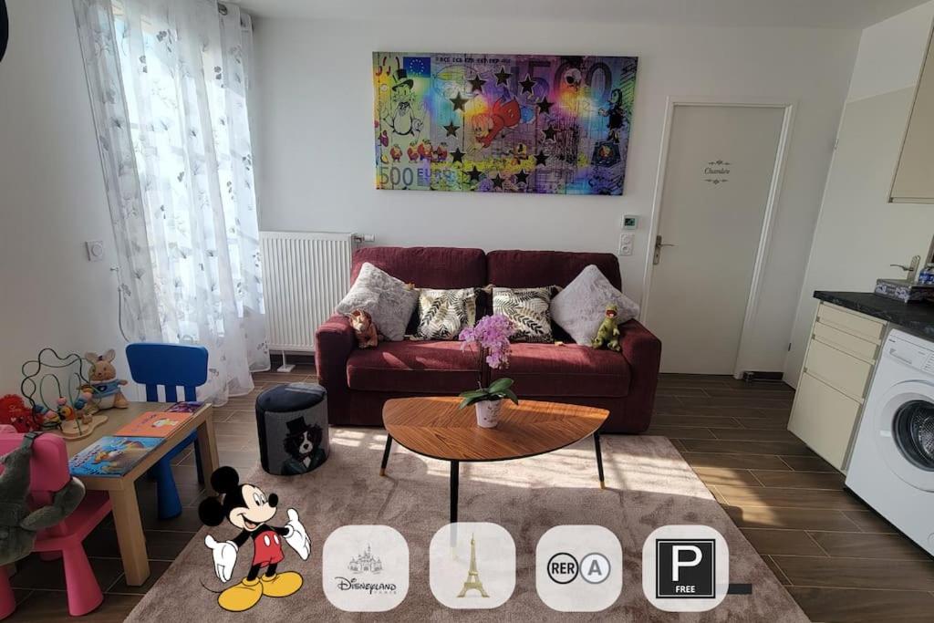 un salon avec un canapé rouge et une table dans l'établissement COSY F2 Proche Disneyland Paris, à Serris