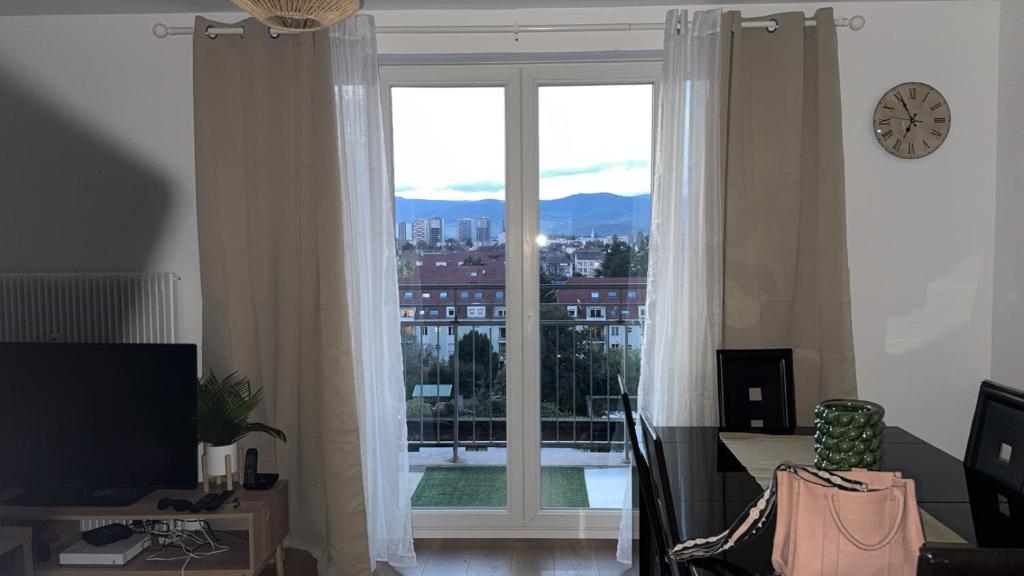 un salon avec une grande fenêtre avec vue dans l'établissement Le sept, à Colmar