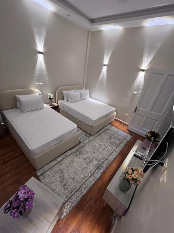 カイロにあるNew Downtown studios in cairoのベッド2台とソファ1台とテーブル1台がある部屋