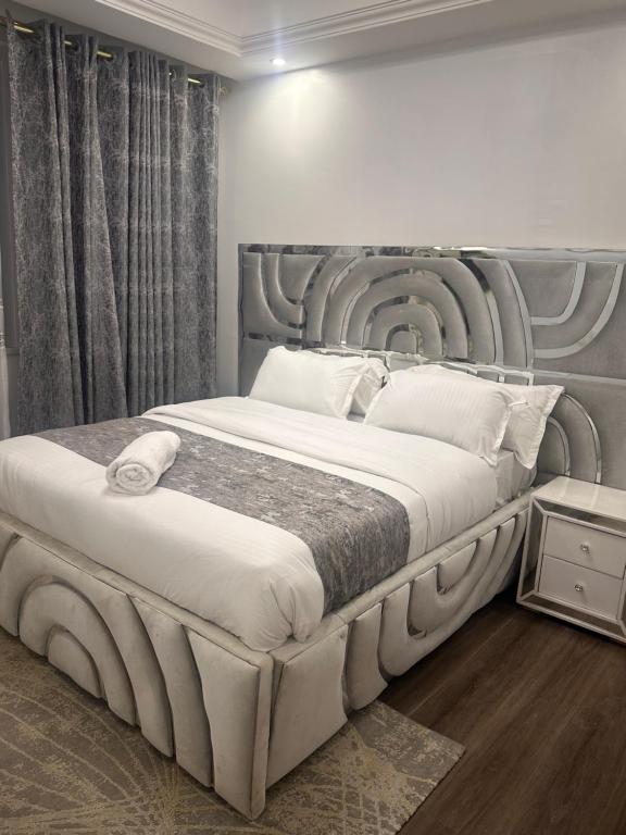 une chambre avec un grand lit avec une grande tête de lit dans l'établissement Hanans luxury Homes, à Nairobi