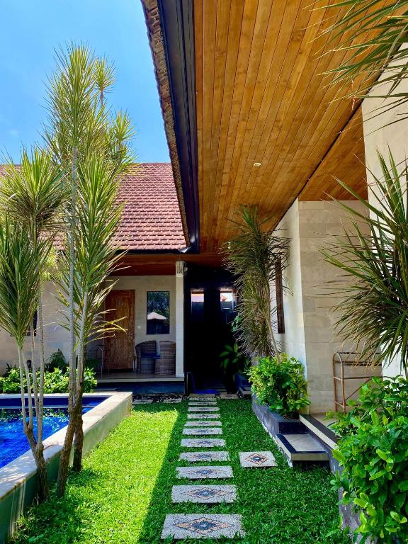 a backyard with a pool and a house at Uma Sindu Homestay in Sanur