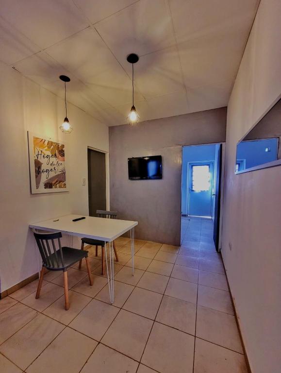 a dining room with a table and a tv at Güemes 4 in General Roca