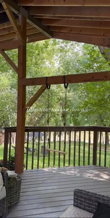 a screened porch with a wooden pergola with a chandelier at No. 5 East in Winnipeg