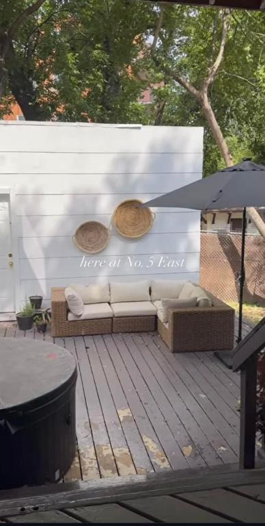 a couch sitting on a wooden deck with a wall at No. 5 East in Winnipeg