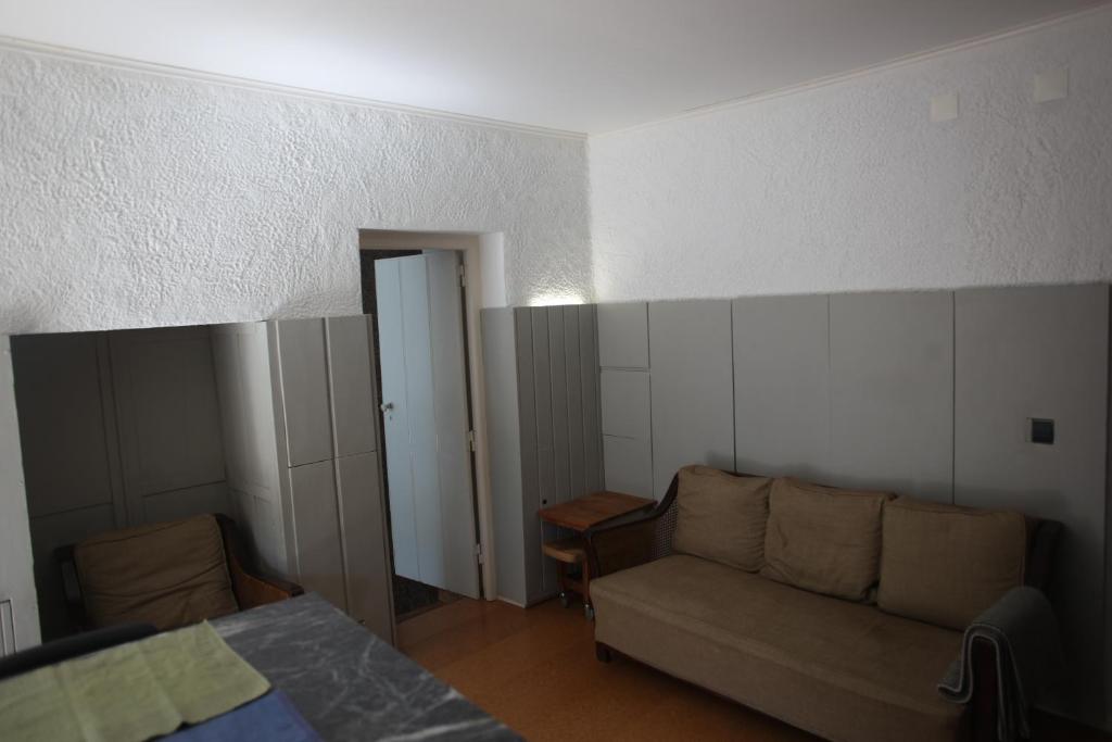 a living room with a couch and a bed at ribeira dos marinheiros amarelo in Sintra
