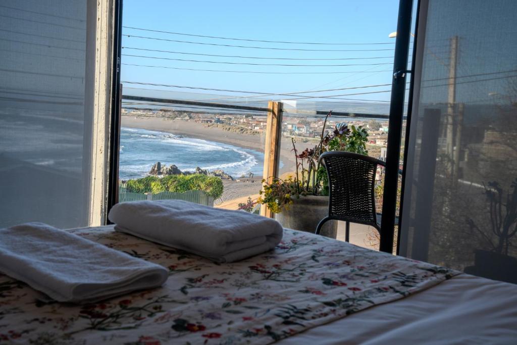 a bedroom with a bed and a view of a beach at Hotel Boutique Aldea del Mar in Pichilemu