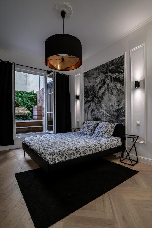 une chambre avec un lit et une grande fenêtre dans l'établissement Le Jeanne d'Arc, à Chinon