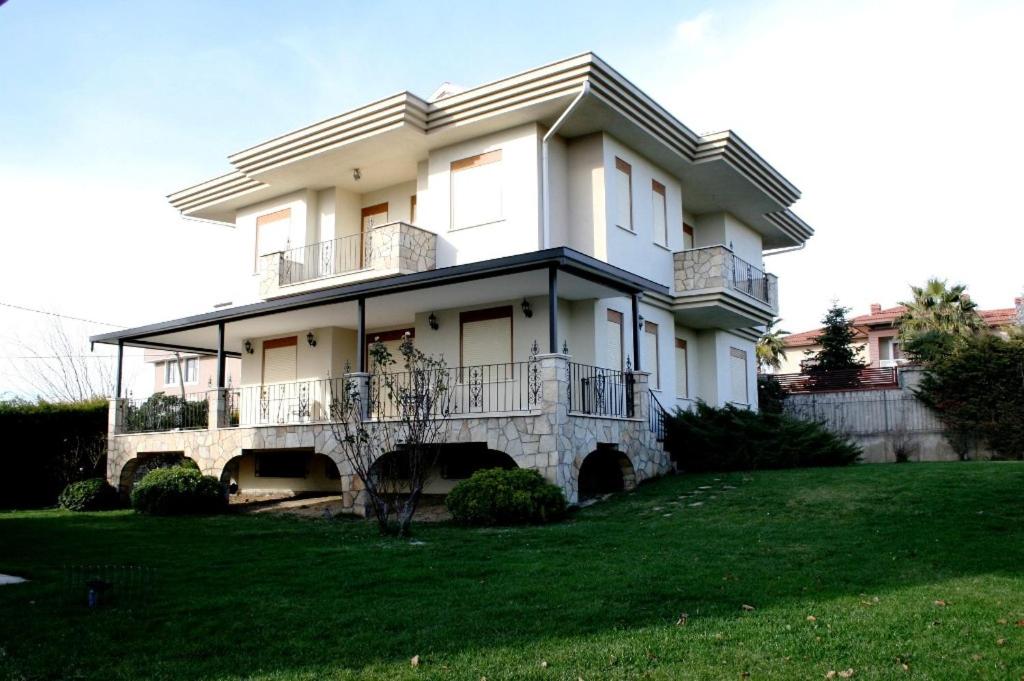 Cette grande maison blanche dispose d'un balcon sur une pelouse. dans l'établissement Villa Bursa, à Bursa