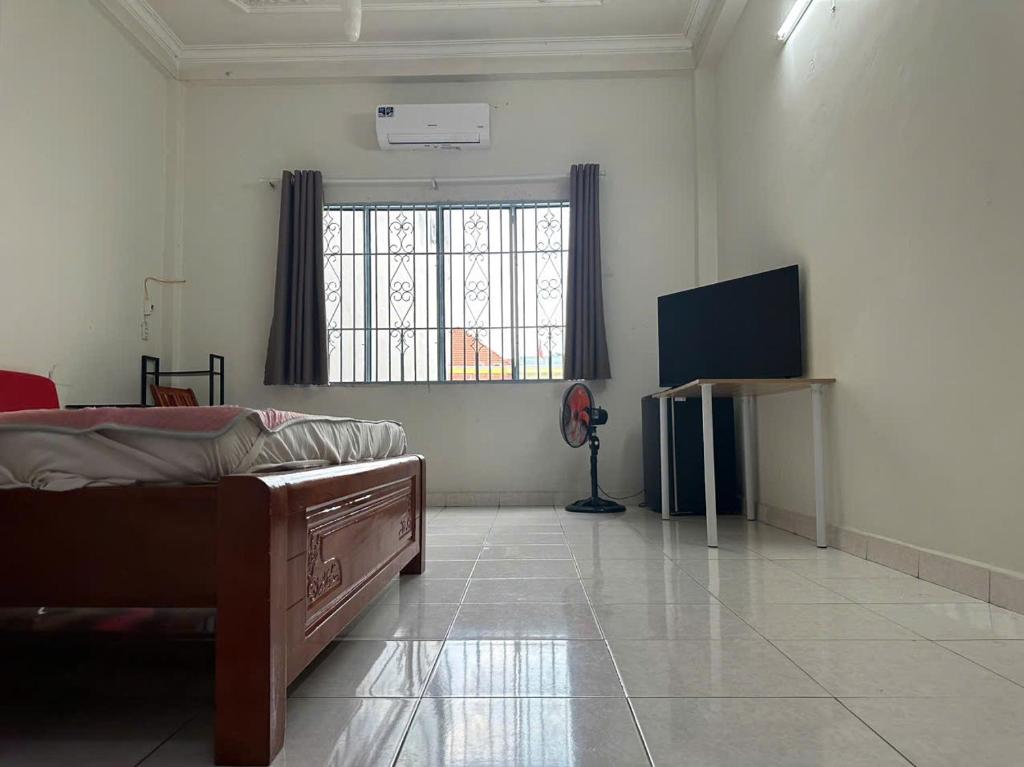 Zimmer mit einem Bett und einem TV in der Unterkunft CoCo home 15 in Ho-Chi-Minh-Stadt