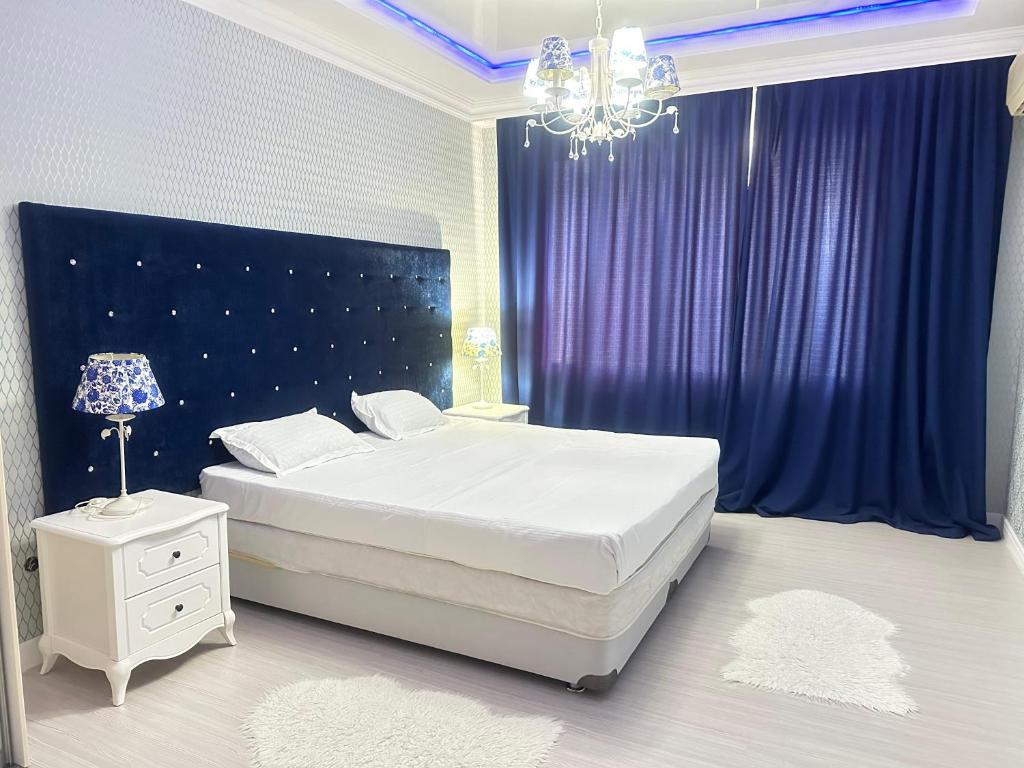 a bedroom with a large bed and a purple curtain at Апартаменты 2 комнатная возле теннисного центра in Aktobe