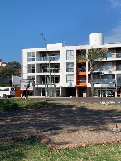 a large white building with a palm tree in front of it at A estrenar con vista al río in Paraná