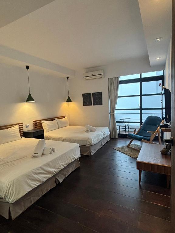 a hotel room with two beds and a desk and a chair at Playful House in Kenting