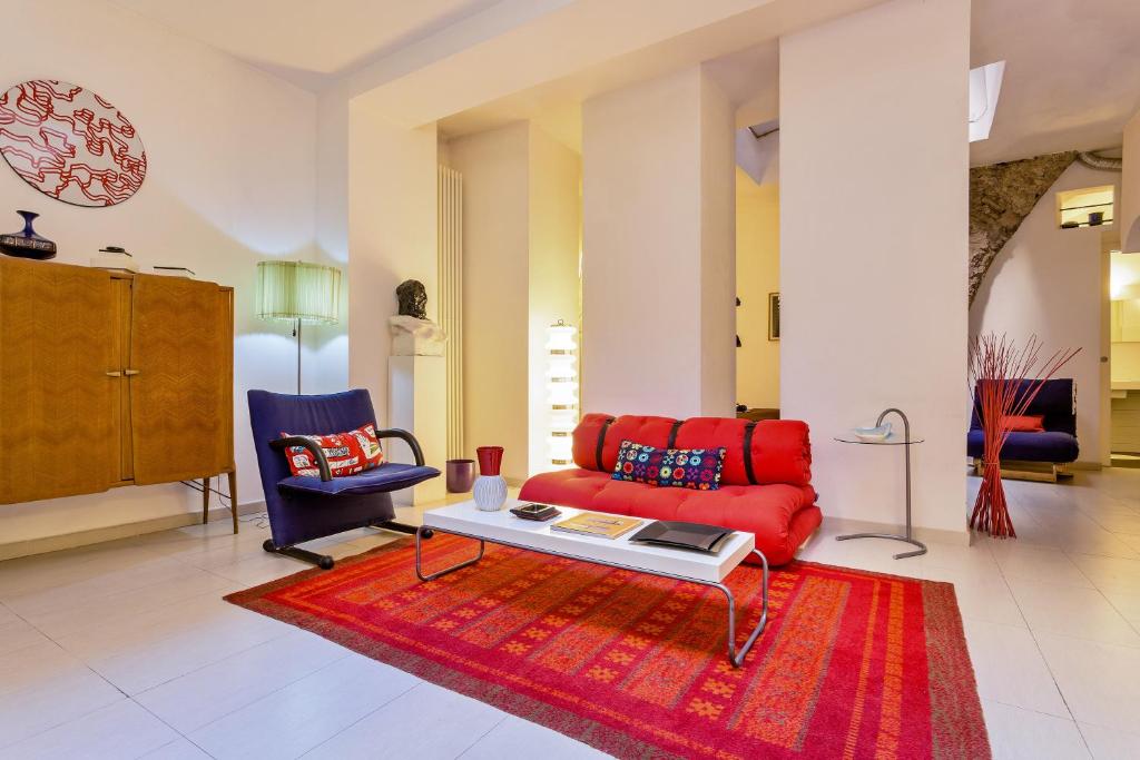 a living room with a red couch and two chairs at Rome as you feel - Selci Apartment in Rome