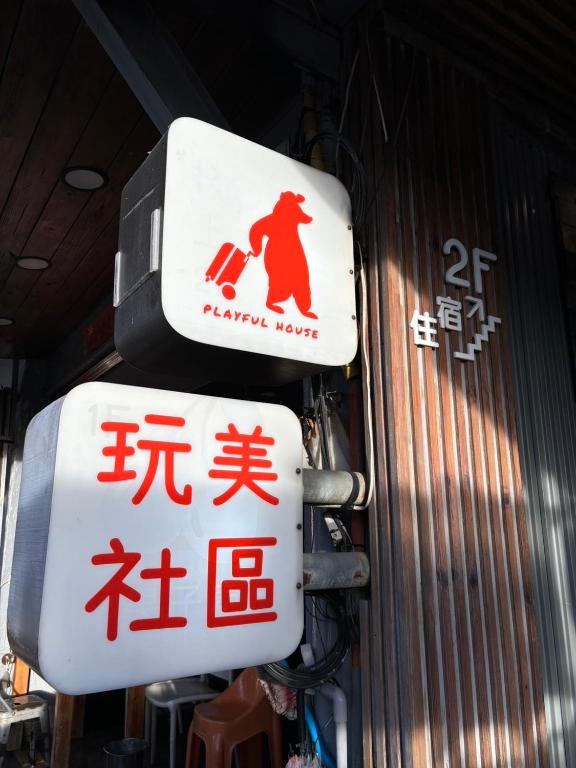 two signs on the side of a building at Playful House in Kenting