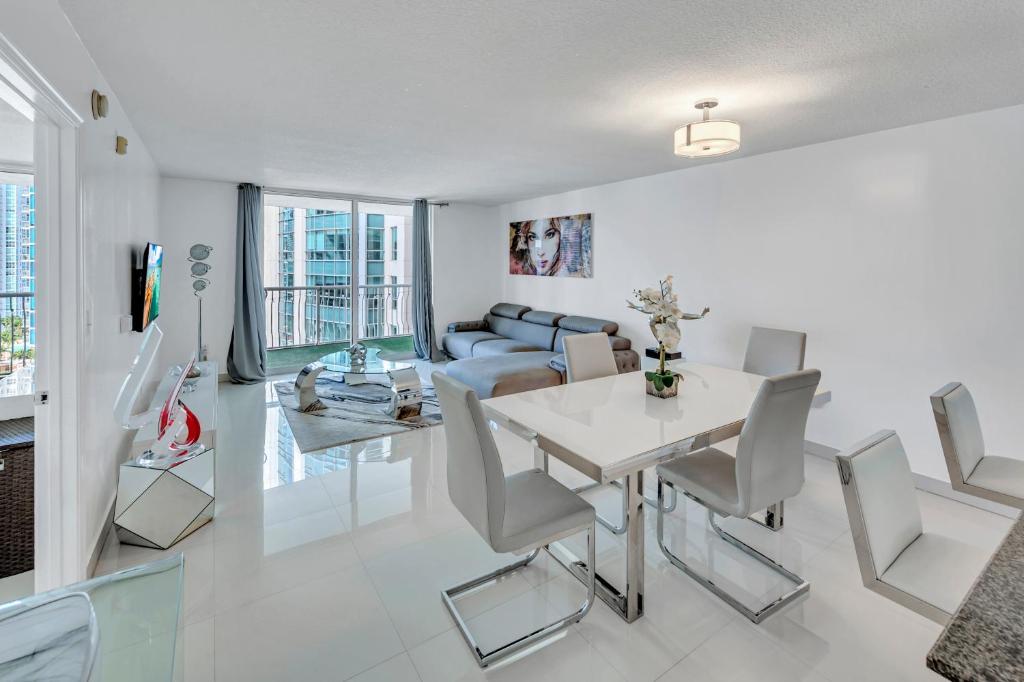 un salon avec une table et des chaises blanches dans l'établissement Amazing 28th floor unit with Parking, à Miami