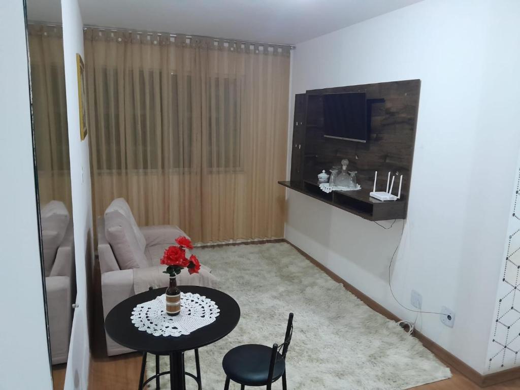 a living room with a table and a couch at Lar feliz in Juiz de Fora