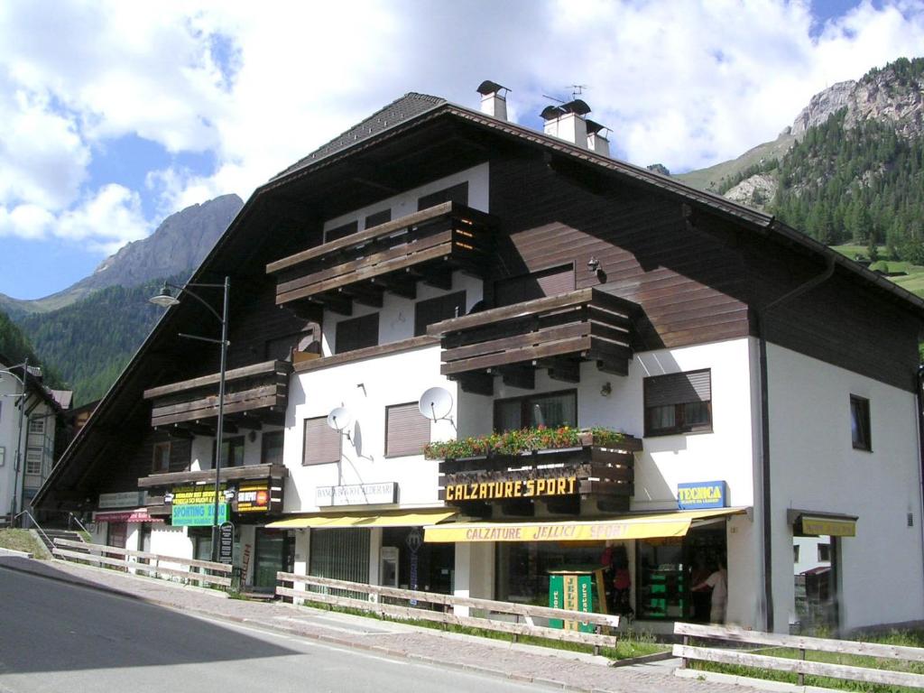 un gran edificio al lado de una calle en La Casa Duron, en Campitello di Fassa