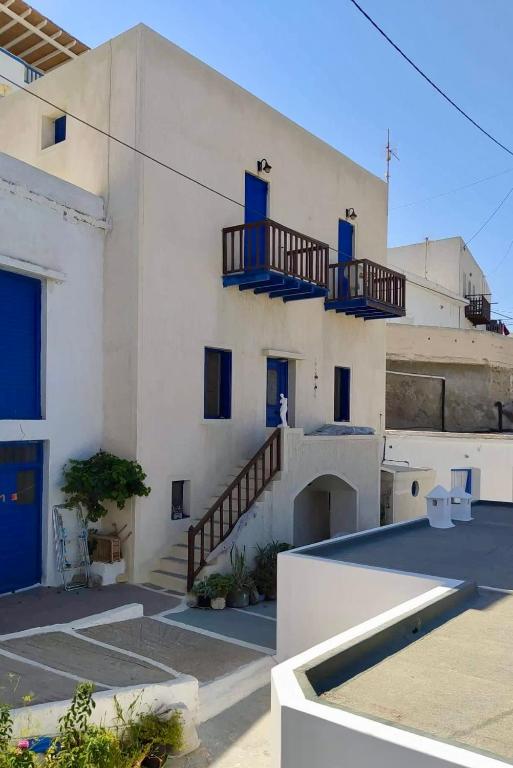 a white building with blue doors and stairs on it at MilosBluePearl in Triovasálos
