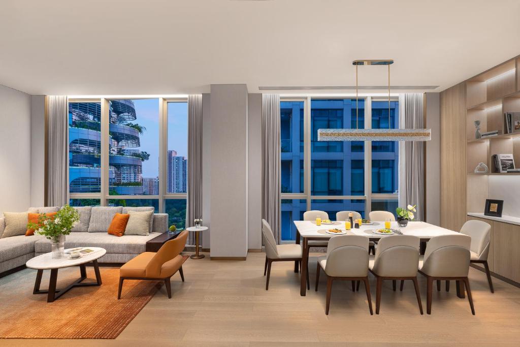 a living room with a table and chairs and a couch at Somerset QPlex Shenzhen in Shenzhen