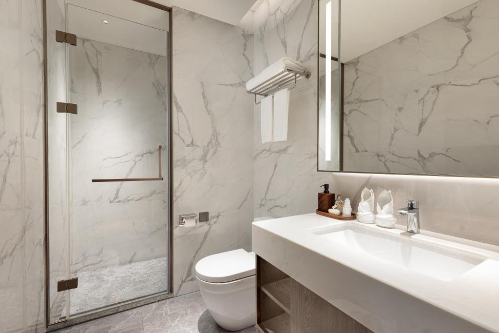 a bathroom with a toilet and a sink and a shower at Somerset QPlex Shenzhen in Shenzhen