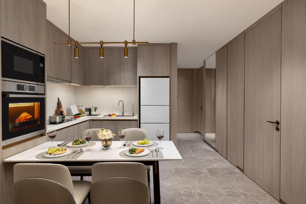 a kitchen with a table and chairs in a kitchen at Somerset QPlex Shenzhen in Shenzhen