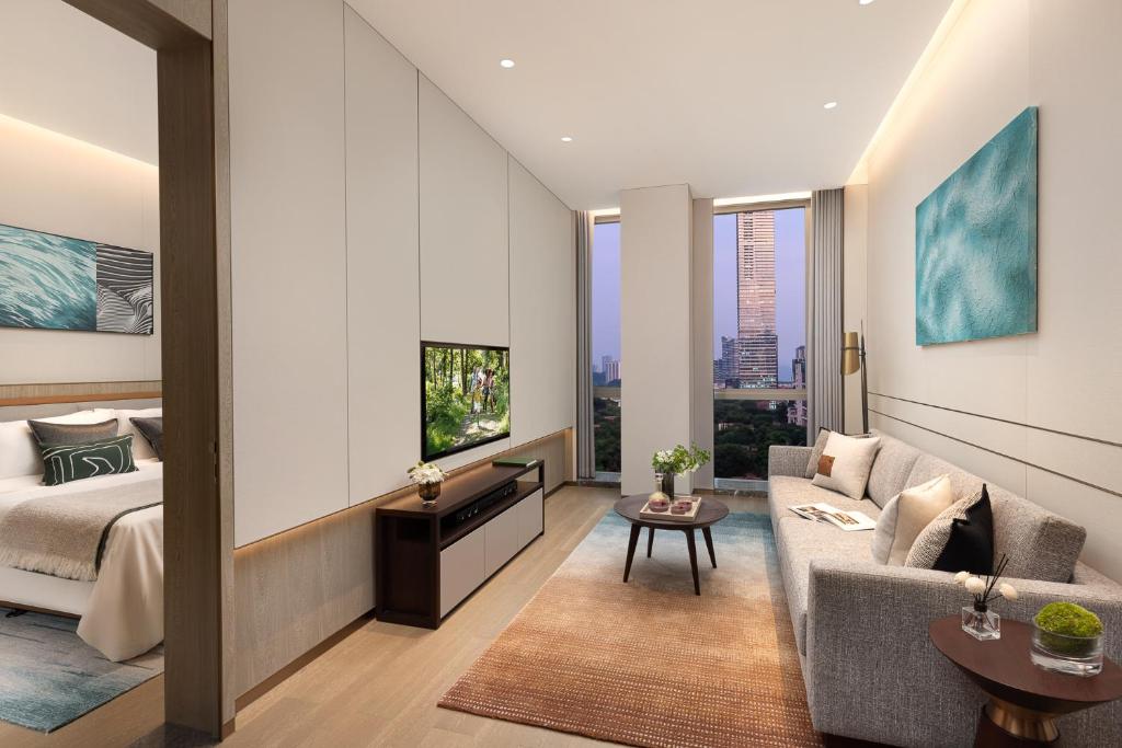 a living room with a bed and a couch at Somerset QPlex Shenzhen in Shenzhen