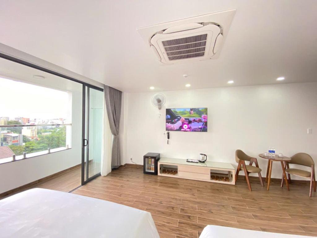 een slaapkamer met een bed, een tafel en een tv bij Golden Hotel in Ho Chi Minh-stad