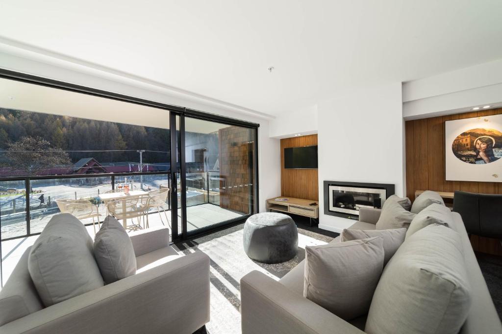 a living room with a couch and a fireplace at Residence du Parc - Luxury Apartment in Queenstown