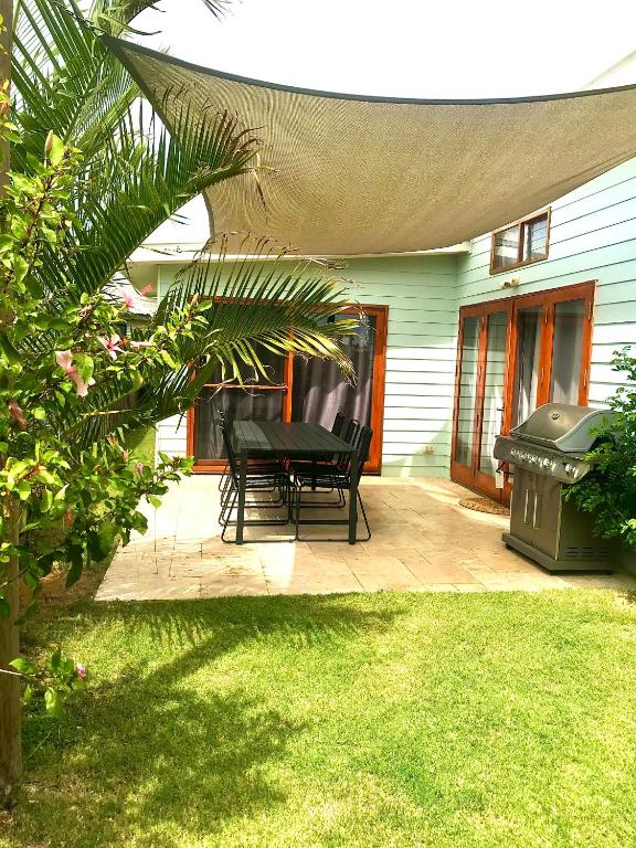 a patio with a black table and chairs on it at Salty Blue Beach House in Kalbarri