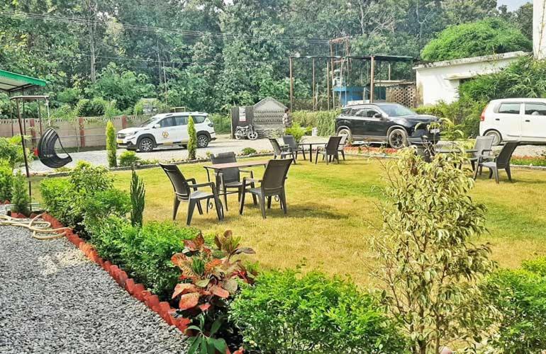 a group of chairs and tables in a yard at Corbett Sunrise India Homestay! in Rāmnagar