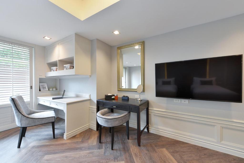 A compact desk and vanity sit beside a wall-mounted television.